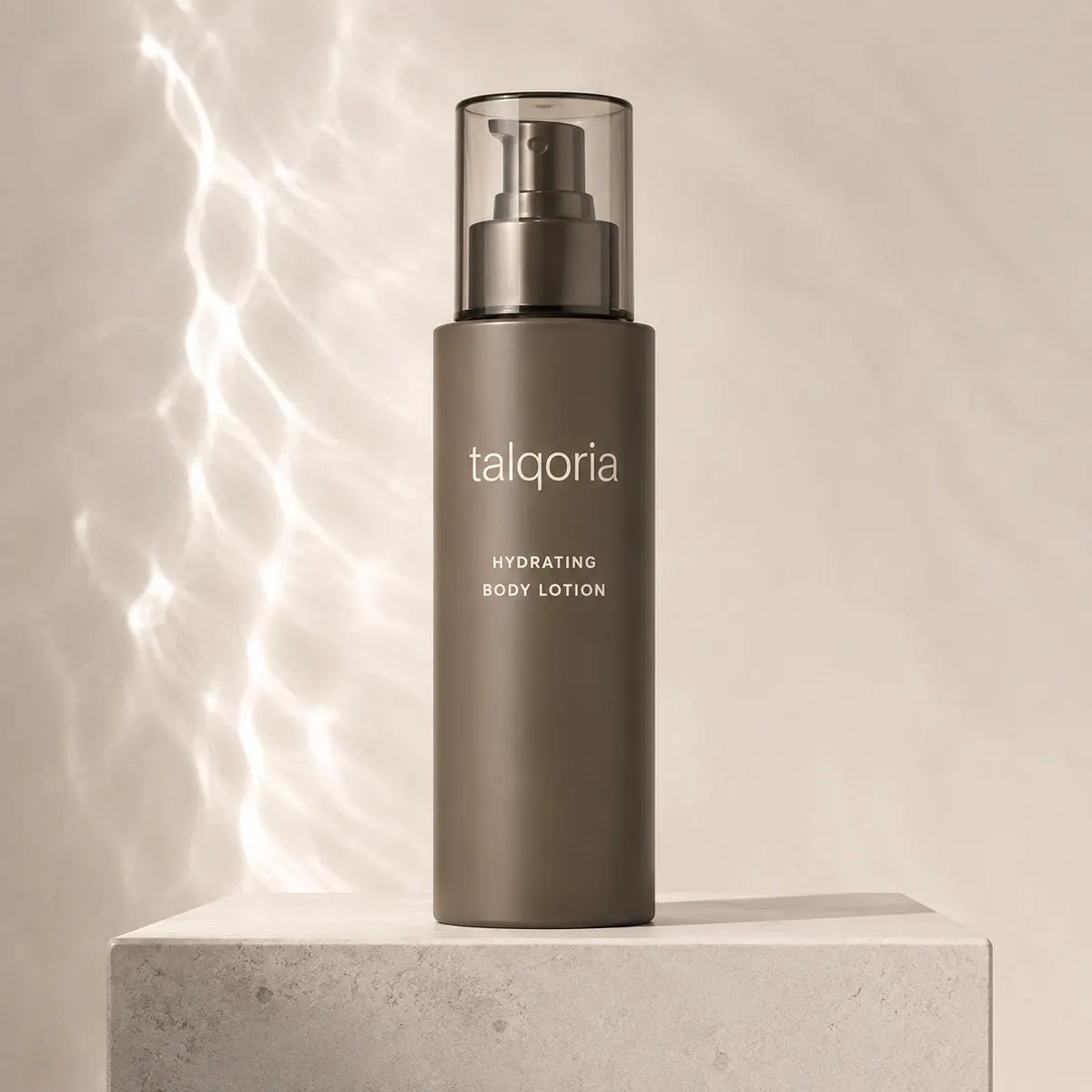 A tall matte taupe body lotion bottle with a clear cap and pump, standing on a light stone pedestal against a warm beige background with soft light streaks.