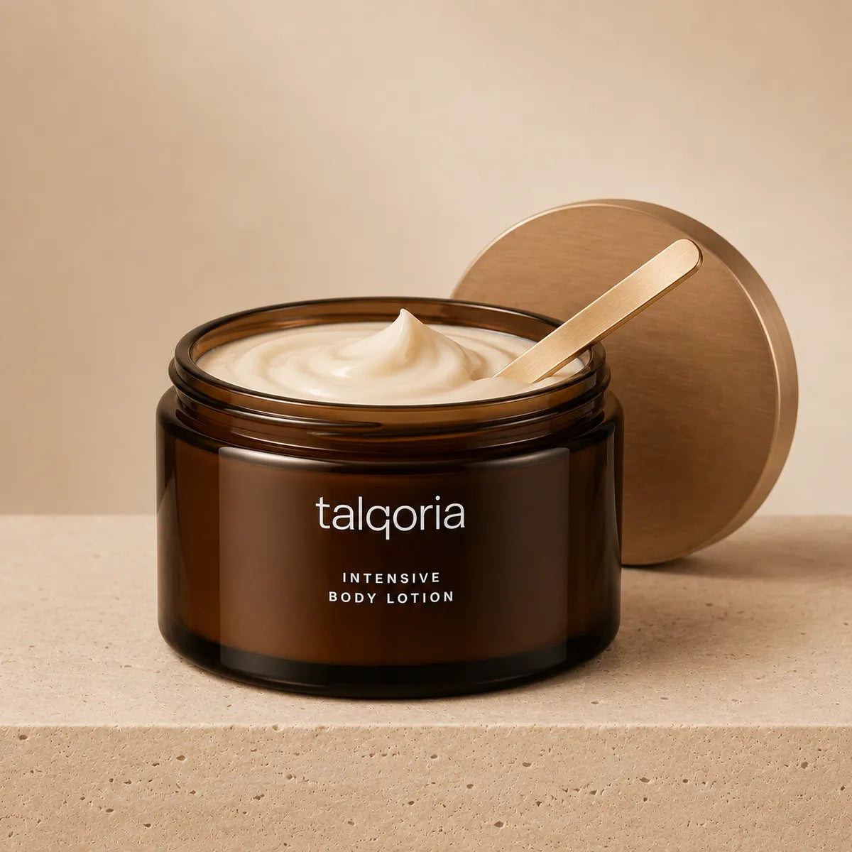 A jar of talqoria Intensive Body Lotion with its lid off, showing the cream inside, set on a textured beige surface with a matching lid leaning behind it.
